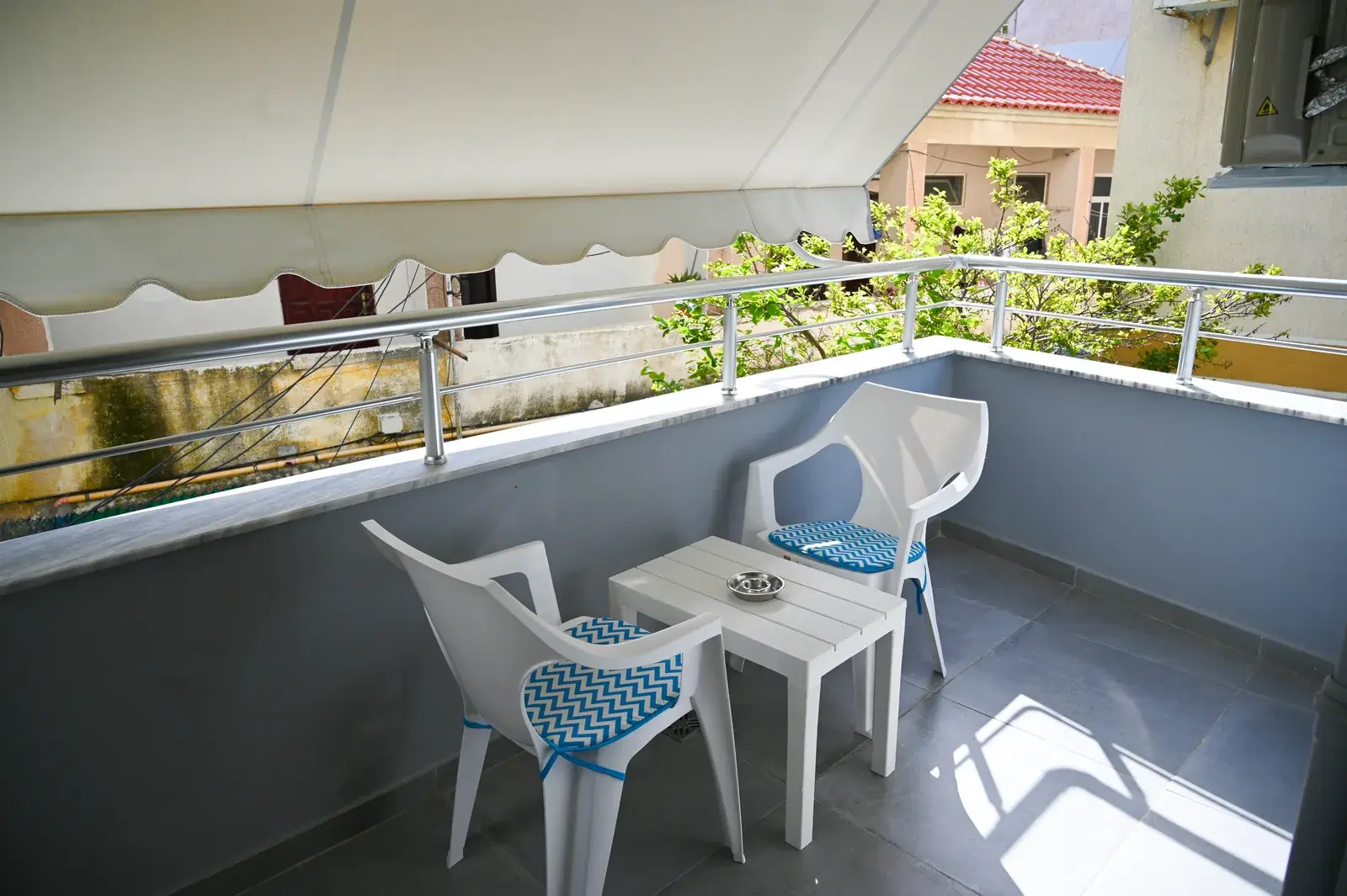 Private balcony with table and chairs onto a quiet side street — Vila Emes, Plazh, Durrës